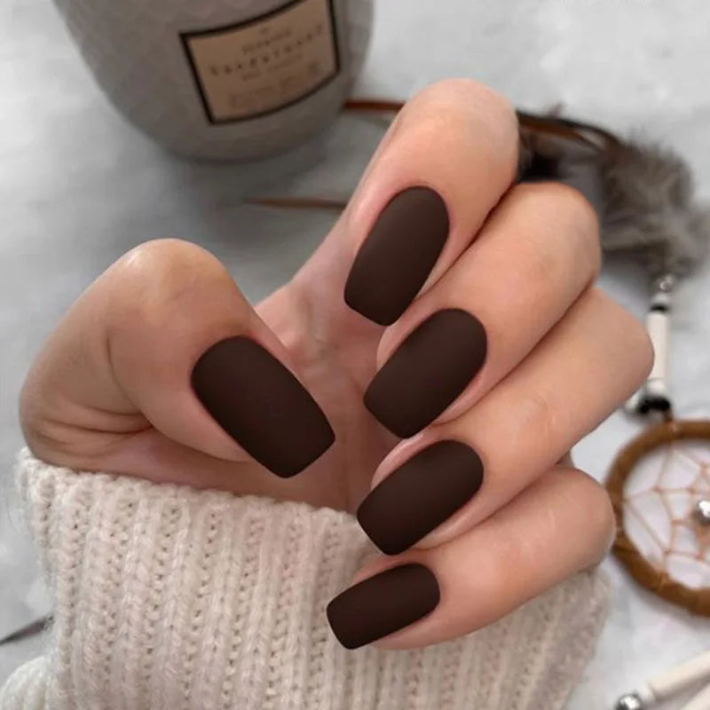 Hand-with-dark-brown-nail-polish-on-a-blurred-background.jpg