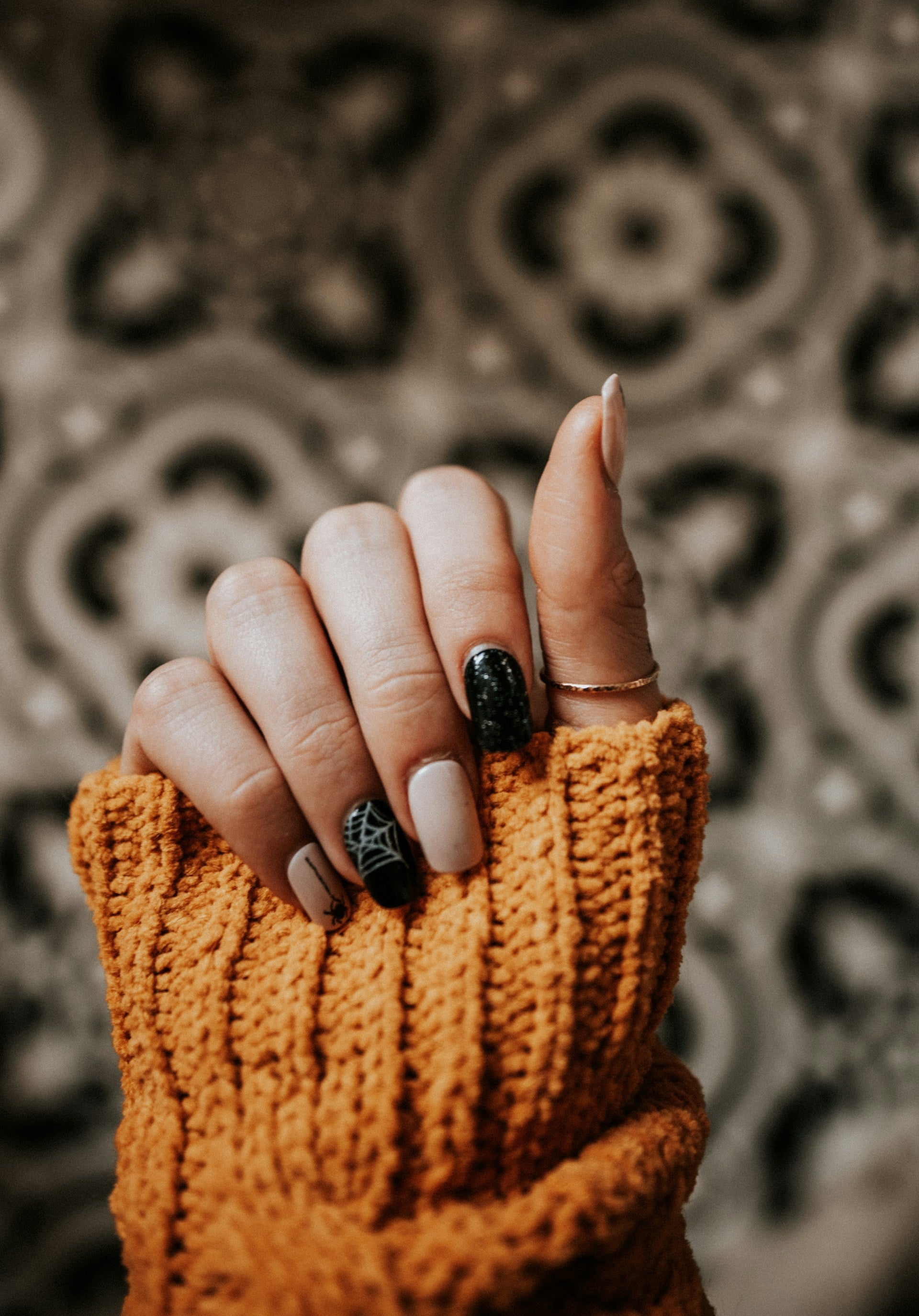 Hand-with-dark-brown-nail-polish-on-a-blurred-background.jpg